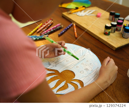 A mother and her young daughter engage in a colorful painting activity  129374224