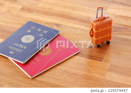 パスポートとスーツケース - パスポート（10年用と5年用）とスーツケースで海外旅行のイメージ 129374447