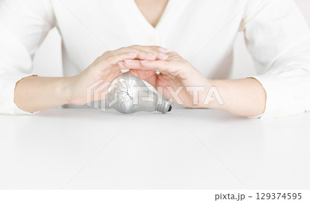 Silver Light Bulb with Brain Texture Protected by Human Hands Silver Light Bulb with Brain Texture Protected by Human Hands 129374595