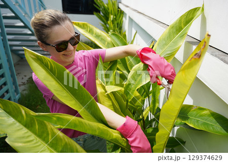 A young woman trims her beautiful garden A young woman trims her beautiful garden 129374629