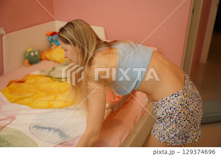 A young woman is enjoying a wonderfully serene morning in her bedroomnd  129374696