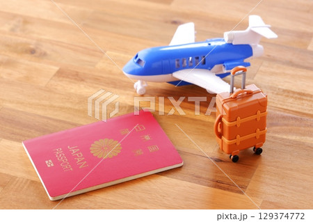日本のパスポート(一般旅券10年用赤色)と飛行機、スーツケースで、海外旅行のイメージ 日本のパスポート(一般旅券10年用赤色)と飛行機、スーツケースで、海外旅行のイメージ 129374772