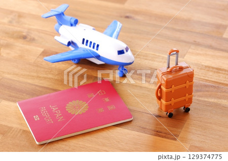 日本のパスポート(一般旅券10年用赤色)と飛行機、スーツケースで、海外旅行のイメージ 日本のパスポート(一般旅券10年用赤色)と飛行機、スーツケースで、海外旅行のイメージ 129374775