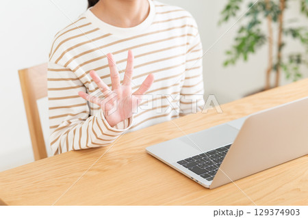 家でパソコンをしながら5本指を立てる中学生の女の子 家でパソコンをしながら5本指を立てる中学生の女の子 129374903