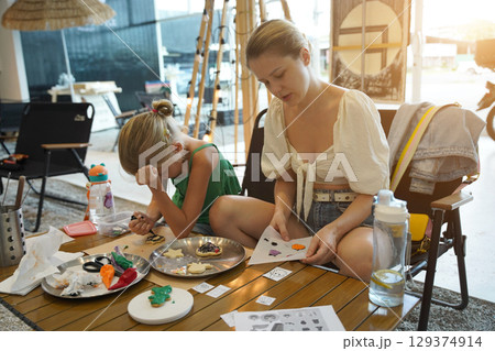 Mother and her daughter paint Halloween cookies Mother and her daughter paint Halloween cookies 129374914