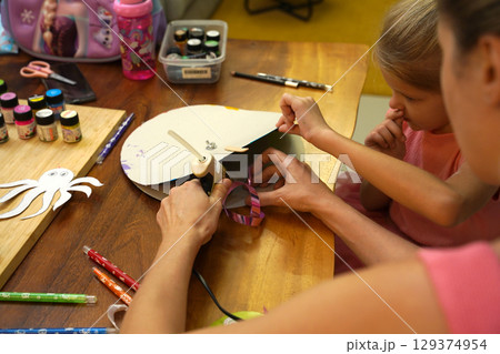 A mother and her young daughter engage in a colorful painting activity A mother and her young daughter engage in a colorful painting activity 129374954