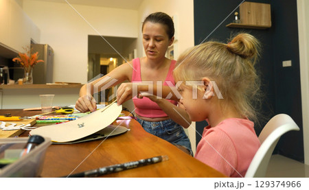 A mother and her young daughter engage in a colorful painting activity  129374966