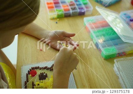 Teacher in workshop teched two girls how to assemble a thermo mosaic Teacher in workshop teched two girls how to assemble a thermo mosaic 129375178
