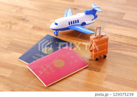 日本のパスポート(5年用と10年用)と飛行機、スーツケースで、海外旅行のイメージ 日本のパスポート(5年用と10年用)と飛行機、スーツケースで、海外旅行のイメージ 129375239