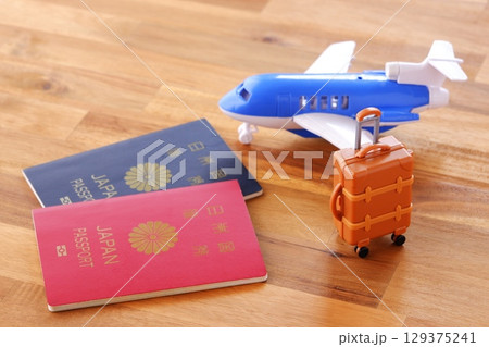 日本のパスポート(5年用と10年用)と飛行機、スーツケースで、海外旅行のイメージ 日本のパスポート(5年用と10年用)と飛行機、スーツケースで、海外旅行のイメージ 129375241