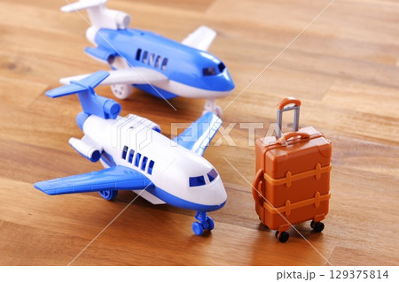 離陸を待つ飛行機とスーツケース（キャリーケース）で、これから旅行に出発するイメージ 129375814