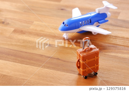 離陸を待つ飛行機とスーツケース(キャリーケース)で、これから旅行に出発するイメージ 離陸を待つ飛行機とスーツケース(キャリーケース)で、これから旅行に出発するイメージ 129375816