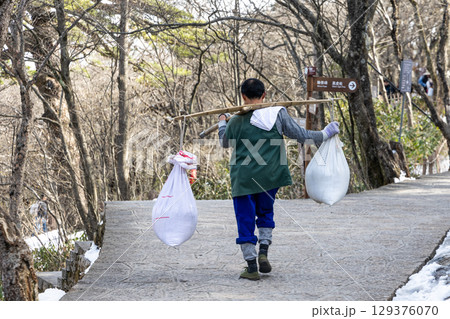 Porter workers carrying construction materials along walking paths at Huangshan or Yellow Mountain. Porter workers carrying construction materials along walking paths at Huangshan or Yellow Mountain. 129376070