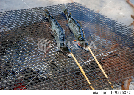 キャンプ場で釣った魚を炭火で塩焼き キャンプ場で釣った魚を炭火で塩焼き 129376077