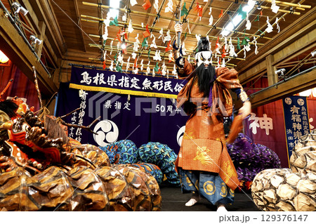 石見神楽 (夜神楽) 神社拝殿舞台で蜷局を巻く大蛇を退治しようとしている主人公の演者 129376147