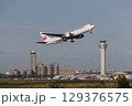 管制塔をバックに離陸する飛行機 129376575