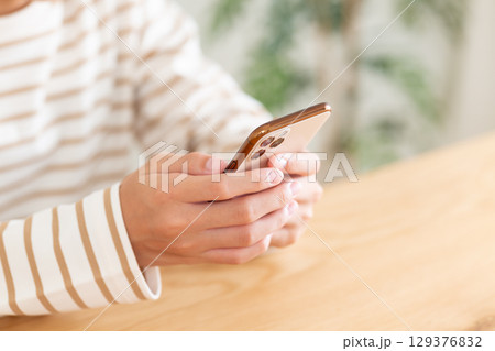家でスマホを操作する中学生の女の子 129376832