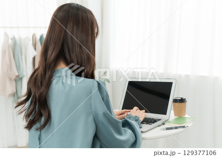 家でパソコンを使って在宅勤務する女性(フルリモート,リモートワーク,テレワーク) 家でパソコンを使って在宅勤務する女性(フルリモート,リモートワーク,テレワーク) 129377106