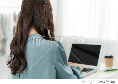 家でパソコンを使って在宅勤務する女性（フルリモート,リモートワーク,テレワーク） 129377108