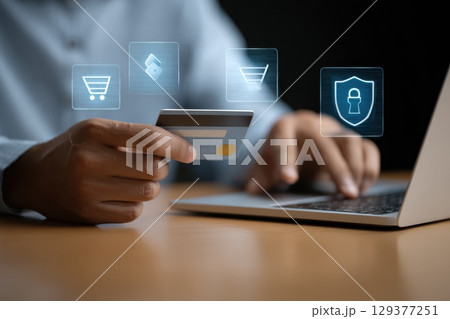 Person Holding Credit Card While Using Laptop for Online Shopping and Digital Transactions 129377251