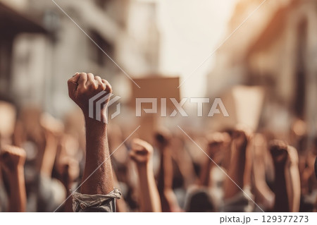 Group of People Participating in Climate Change Protest with Raised Fists and Signs 129377273