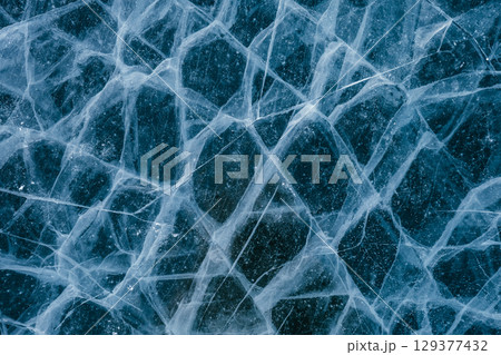 patterns of Baikal ice. frozen lake Baikal with ice floes and cracks. blue textured ice background patterns of Baikal ice. frozen lake Baikal with ice floes and cracks. blue textured ice background 129377432