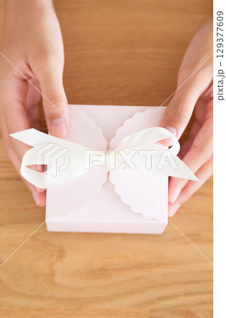 プレゼントを持つ中学生の女の子の手元 129377609