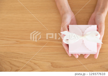 プレゼントを持つ中学生の女の子の手元 129377610