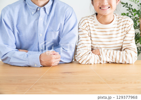 室内で微笑む中学生の女の子とお父さん 129377968