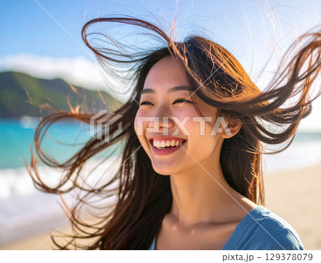 海風に吹かれる若い女性/ Young woman blown by sea breeze	 129378079