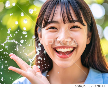 水で遊ぶ若い女性/young woman playing in water	 129378114