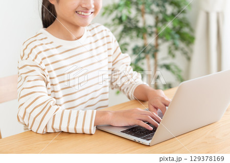 家でパソコンをする中学生の女の子 129378169
