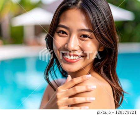 プールで遊ぶ若い女性/ Young woman playing in the pool	 129378221