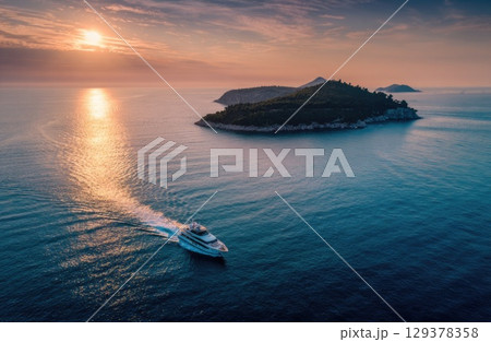 A luxury yacht sailing between islands in the sea drone shot. 129378358