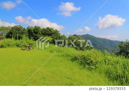 草原　樹木　青空　雲　山地　テーブル　ベンチ 129378555