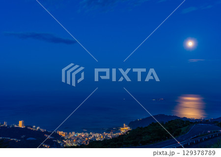 （静岡県）伊豆スカイライン道路から見る熱海の街並み、相模灘に満月昇る 129378789