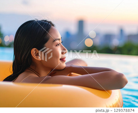 プールでくつろぐ若い女性/ Pūru de kutsurogu wakai josei Young  129378874