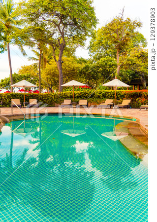 Umbrella and chair around swimming pool in resort hotel for leisure travel and vacation neary sea ocean beach Umbrella and chair around swimming pool in resort hotel for leisure travel and vacation neary sea ocean beach 129378903