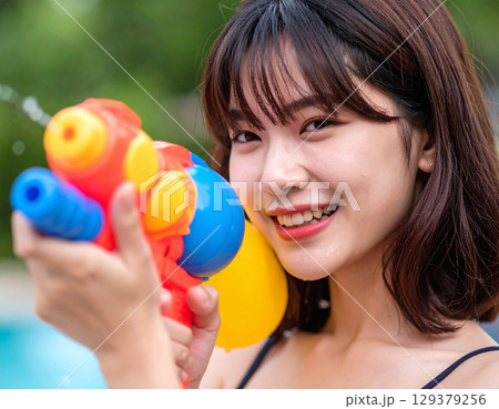 水鉄砲で遊ぶ若い女性 129379256