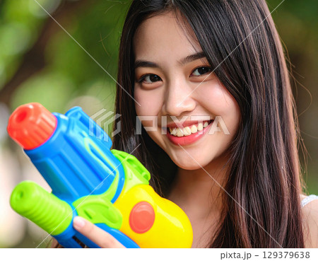 水鉄砲で遊ぶ若い女性 129379638
