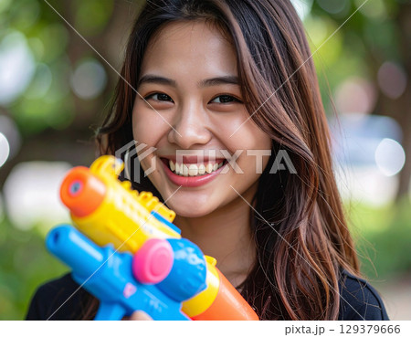 水鉄砲で遊ぶ若い女性 129379666