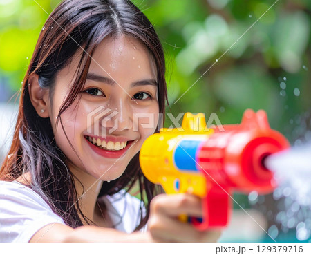 水鉄砲で遊ぶ若い女性 129379716