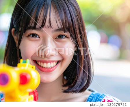 水鉄砲で遊ぶ若い女性 129379731