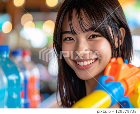 水鉄砲で遊ぶ若い女性 水鉄砲で遊ぶ若い女性 129379738
