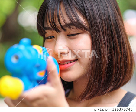 水鉄砲で遊ぶ若い女性 129379740