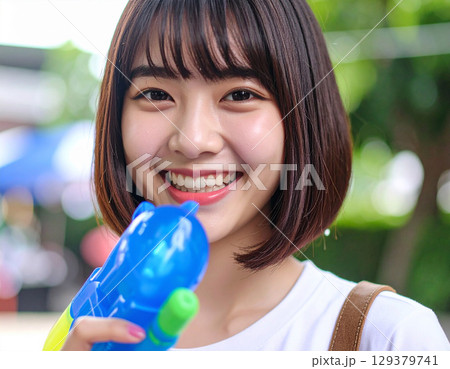 水鉄砲で遊ぶ若い女性 129379741