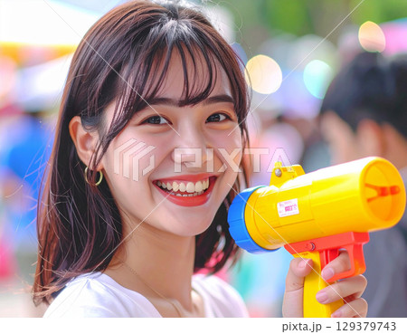 水鉄砲で遊ぶ若い女性 129379743