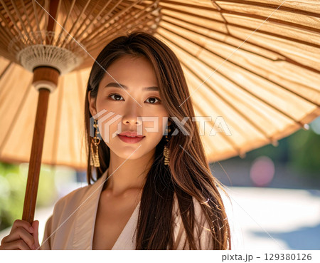 日傘をさす若い女性/Young woman holding a parasol	 129380126