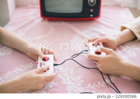 ゲームのコントローラーを持つ手元 129380566