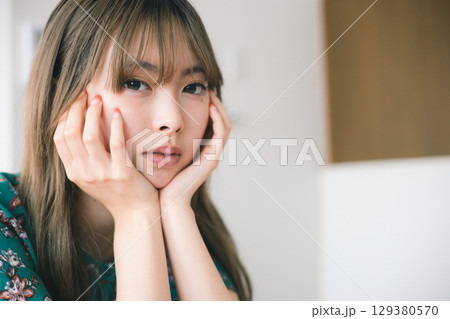 頬杖をつく若い女性 頬杖をつく若い女性 129380570